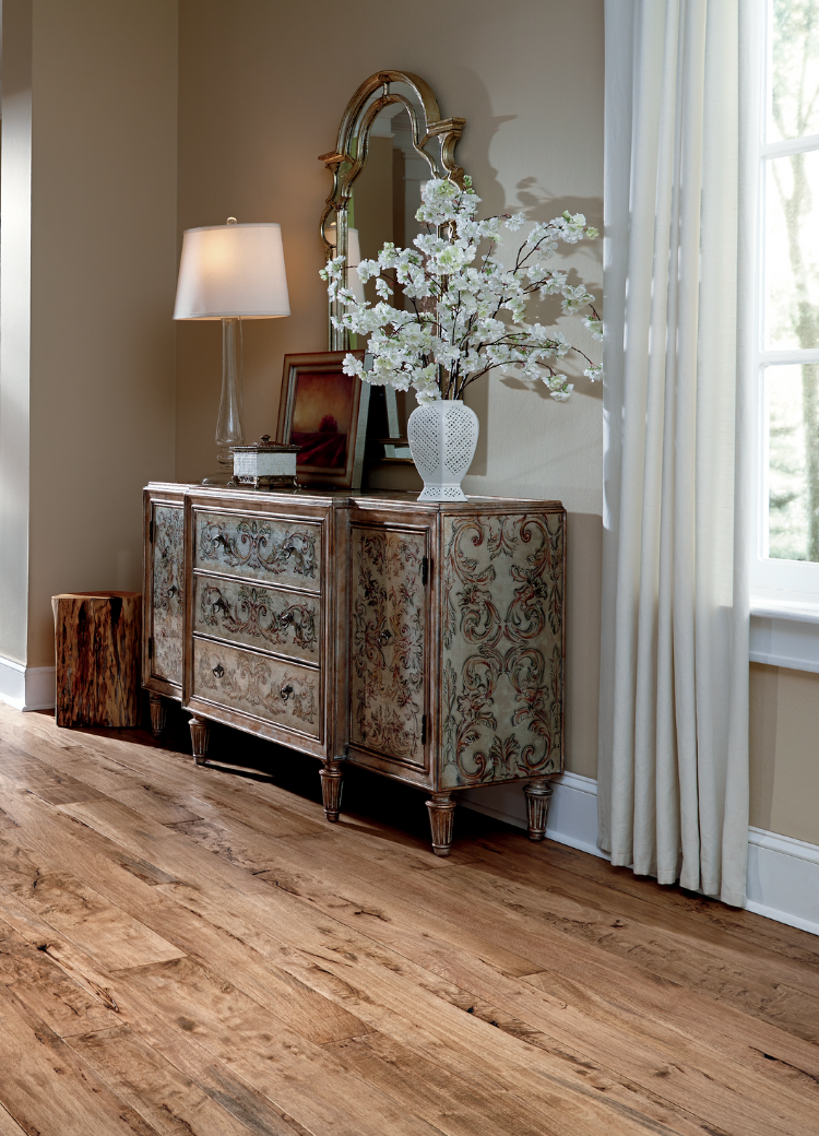 warm toned hardwood flooring in living room with white couch and natural decor.